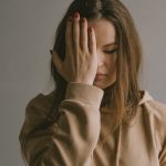a woman covering her face with her hands